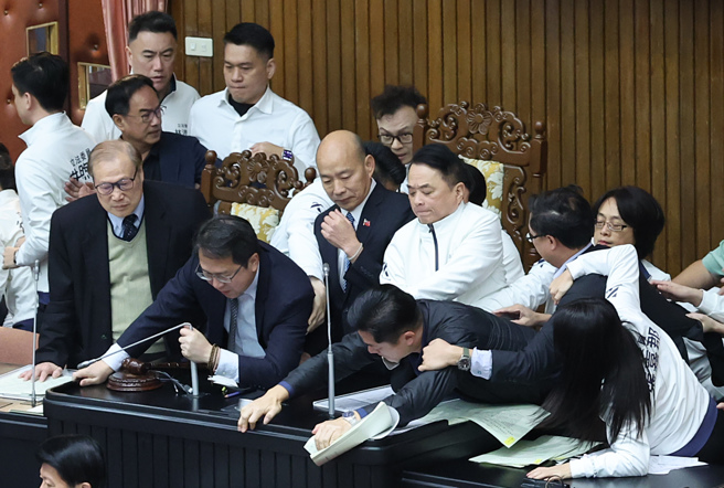 立法院6日院會，國民黨提出變更議程案，欲將「選罷法」修正案排入議程，民進黨立委趁機衝上主席台杯葛議事，國民黨立委立即上前保護院長韓國瑜並搶回主席台，藍綠爆發拉扯推擠衝突。（姚志平攝）