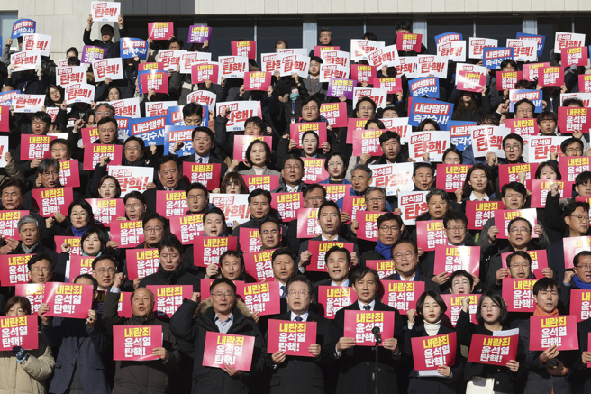 南韓最大在野黨共同民主黨黨魁李在明（前排右五）6日率其他在野黨與民間社團代表齊聚國會外，手持標語疾呼「彈劾尹錫悅」。（美聯社）