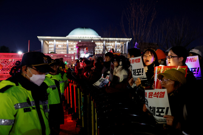 南韓國會外圍6日晚間聚集大批不滿總統尹錫悅的民眾，要求當局逮捕、懲處日前發布戒嚴令的尹錫悅。（路透）