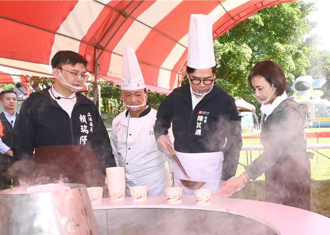 高雄市长陈其迈（右二）7日出席路竹番茄节活动，他拿起勺子舀番茄汤，民进党立委邱议莹（右）在旁帮忙。（林瑞益摄）