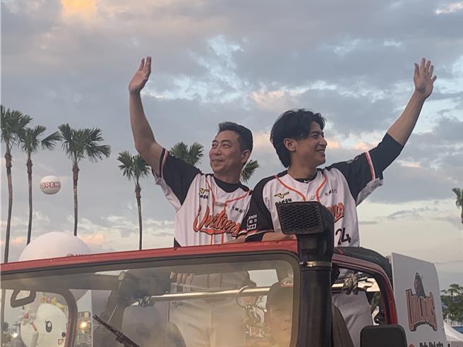 12强冠军队投手教练林岳平（左）、台湾队长陈杰宪（右）参加大气球游行庆功，在吉普车上向热情的球迷挥手致意。（郭良杰摄）