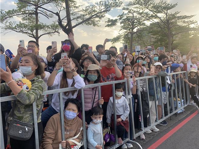 大气球游行现场挤进上万名球迷，纷纷拿起手机拍他们心中的冠军英雄。（郭良杰摄）