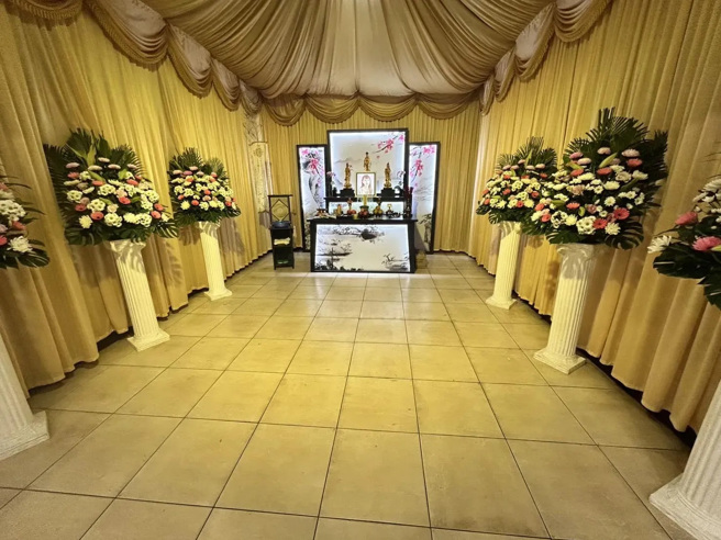 陈梅慧的灵堂于殡仪馆内布置完成，但家属处理极为低调，灵堂未标明姓名，仅摆放遗照及未署名的花篮。（图／翻摄中天新闻）