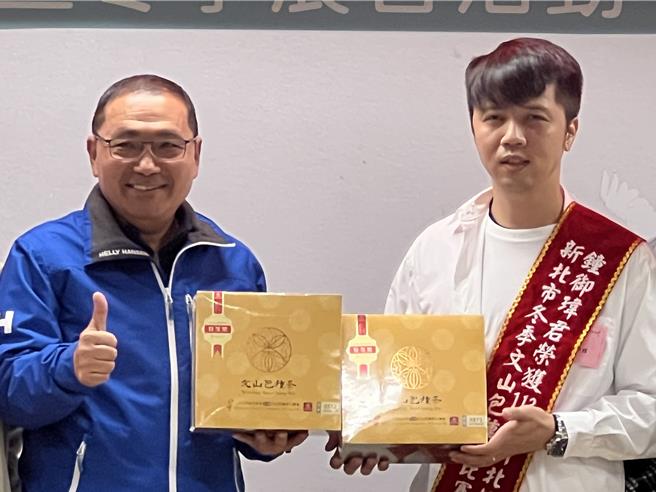 钟御玮回赠自家生产的冠军茶给侯友宜。（王扬杰摄）