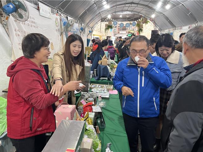 假日市集的商家邀请侯友宜品嚐好茶。（王扬杰摄）