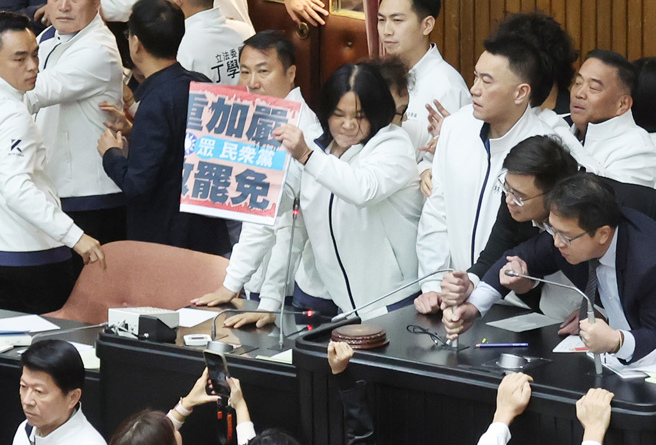 立法院6日院會，國民黨提出變更議程案，欲將「選罷法」修正案排入議程，引爆藍綠搶占主席台衝突，國民黨立委陳玉珍（中）不僅從台下爬上主席台，還一把扯下民進黨立委手板丟一旁，嗆民進黨「戰鬥力那麼弱，占什麼主席台！」（資料照／姚志平攝）