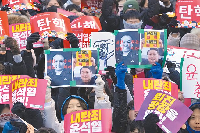 韓國民眾高舉標語，要求彈劾韓國總統尹錫悅。（美聯社）