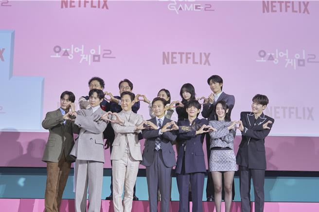 《鱿鱼游戏》第二季演员群开心比爱心，前排左起李阵郁、朴成焄、李政宰、李炳宪、任时完、朴珪瑛、姜河那，后排左起梁东根、李书焕、康爱心、曹柔理、魏嘏隽盛装出席。（Netflix提供）