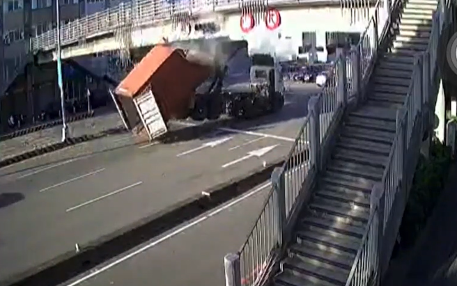 一辆货柜车行经台湾大道八段时，疑似因货柜未固定好，超高部分直接撞上天桥。（萧宥彤翻摄）