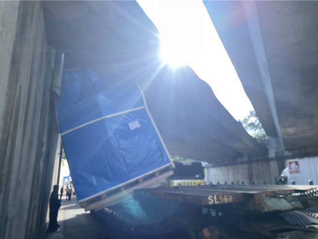 联结车未注意货物高度，卡在台66桥墩动弹不得。(警方提供／吕筱蝉桃园传真)