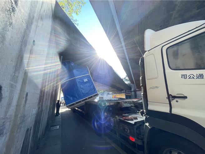 联结车未注意货物高度，卡在台66桥墩动弹不得。(警方提供／吕筱蝉桃园传真)
