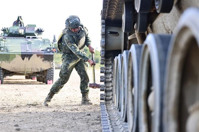  官兵以鐵鎚敲擊戰車履帶鬆脫部位，使其牢固。（記者劉宸瑋攝）