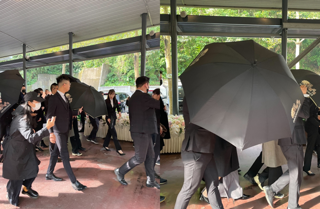 家属离开火化场，为躲开媒体拍摄，以层层黑伞包围。（林淑娟摄）