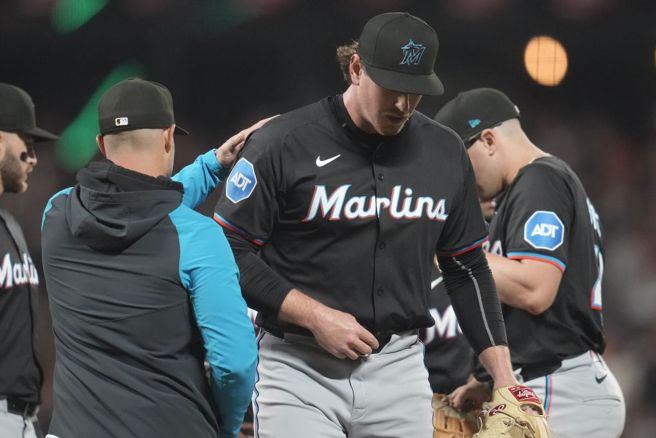中繼投手鮑曼（中）被馬林魚總教練修梅克換下場。（美聯社資料照）