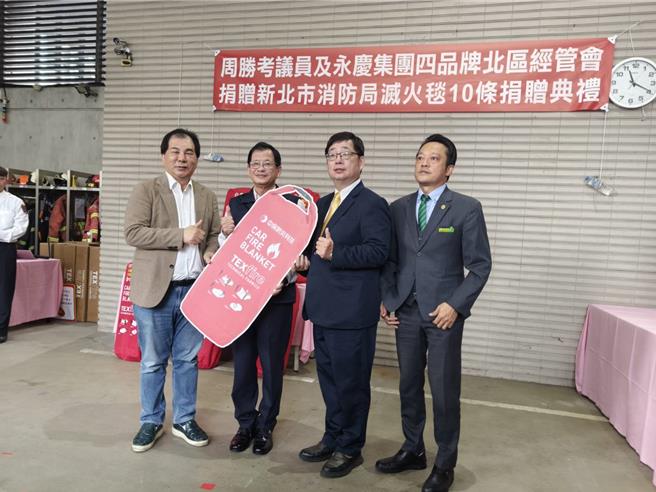 永庆集团四品牌北区经管会捐增灭火毯给新北市消防局，左起新北市议员周胜考、消防局长陈崇岳、永庆集团北区经管会会长杨世旭、许哲玮。（新北市消防局提供）