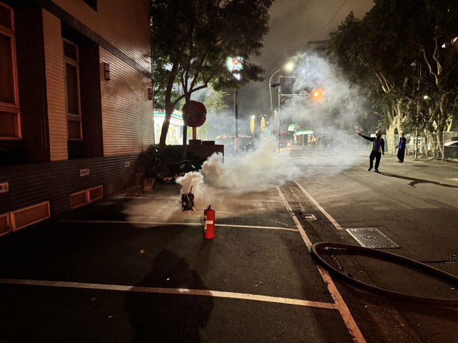 外籍移工的电动车锂电池故障冒烟，消防队到场立即分离并洒水降温。（翻摄画面）