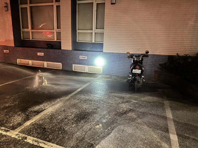 外籍移工的电动车锂电池故障冒烟，消防队到场立即分离并洒水降温。（翻摄画面）