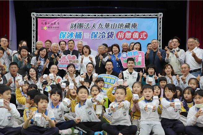 12日举行捐赠仪式，民族国小学生拿着刚到手的鲜奶一起参与。（吕妍庭摄）