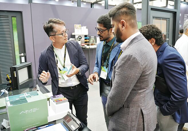 AIM风光滤膜总经理邱建宇（左一）跟国外客户介绍「风光节能玻璃」优异的节能效果。图／业者提供