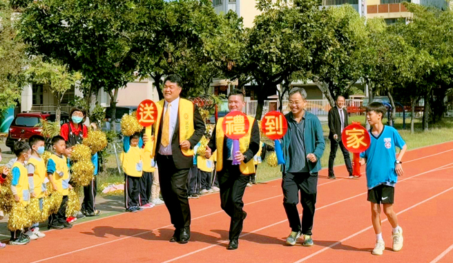 永庆不动产暨永义房屋台南区经管会长吕启纶(图左1)、有巢氏房屋暨台庆不动产台南区经管会长谢旺玮(图左2)以及崇学国小师生们，齐心祝福「寒士吃饱30」募款达标。(图/永庆房产集团提供)