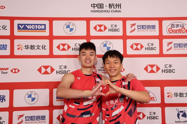 羽球男双组合「麟洋配」最后一次在国际赛合体，赛后受访时王齐麟（左）、李洋（右）一起搭肩比出爱心手势。（羽球协会提供）