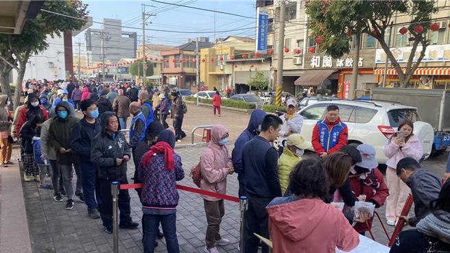 立委杨琼璎团队于后里区镇安宫前发送600份水果月历及150份「封王鸡排」，一早涌现长长排队人龙索取。（张妍溱摄）
