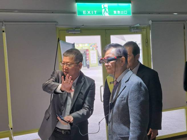 佐臻股份有限公司董事长梁文隆（左）介绍，AR、VR技术，图为汤志民（右）体验AR智慧眼镜。（温予菱摄）