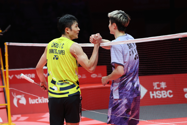 周天成(左)賽後與石宇奇在網前握手請安。(羽球協會供應)