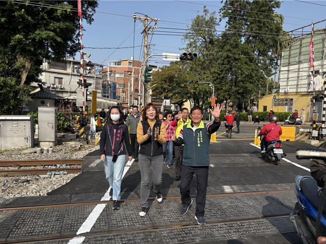 台南市北区实践街平交道恢復通行，北区区长潘宝淑（中）与永祥里长李青春（右）、北门里长许雅晴（左）都到现场跟居民一起抢头香过铁支路。（程炳璋摄）