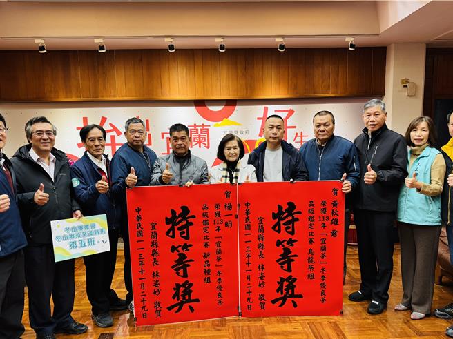 「宜蘭縣冬季優良茶品級評鑑比賽」出爐，由常勝軍冬山鄉黃秋雄（右五）、楊一明（左五）奪下烏龍茶組、新品種茶組的特等獎，縣長林姿妙（中）16日特公開表揚親贈紅榜祝賀。（吳佩蓉攝）