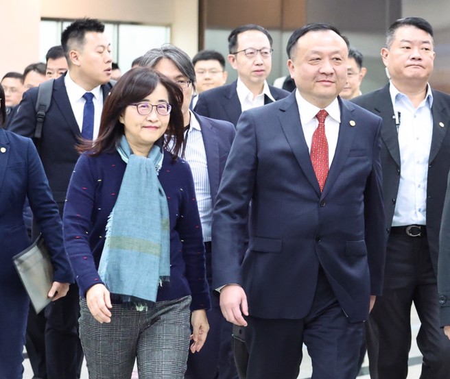 上海市副市长华源（红领带者）16日中午率上海团主团来台，台北市副市长林奕华（戴围巾者）前往接机。（邓博仁摄）