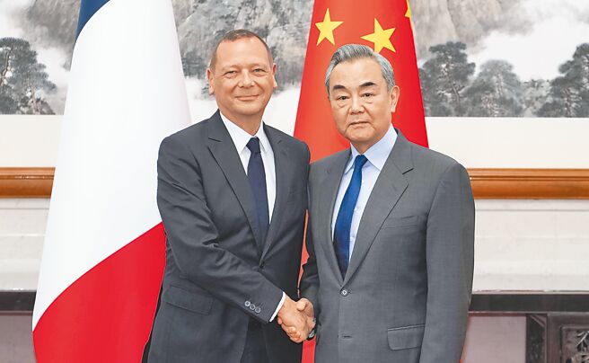 中共中央政治局委员、中央外办主任王毅（右）与法国总统外事顾问伯纳，14日在北京举行中法战略对话。（新华社）