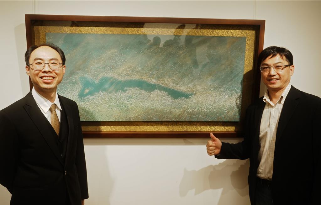 華梵佛藝系主任陳俊吉（左）與作品〈安祥自在〉。（華梵大學提供）