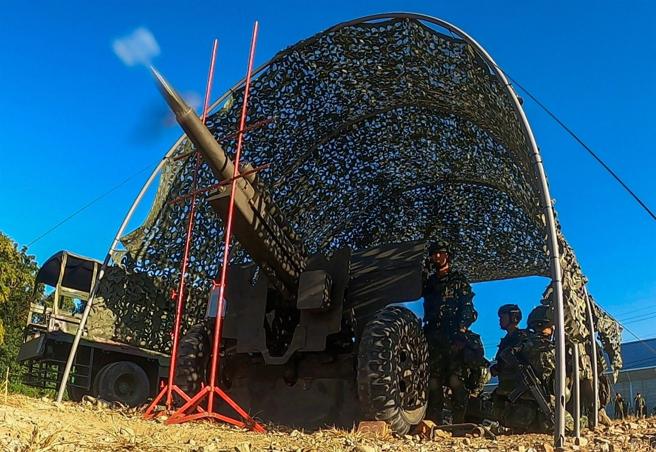  官兵熟练操作105榴炮，发射手迅速拉动火绳，炮弹出膛飞向目标区。（记者林睿奕摄）