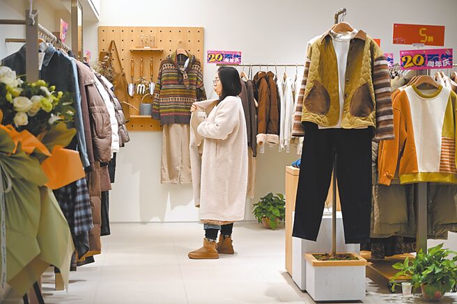 中共中央财办16日表示，明年将实施提振消费专项行动。图为内蒙古呼和浩特市，一位女士选购服装。（中新社）