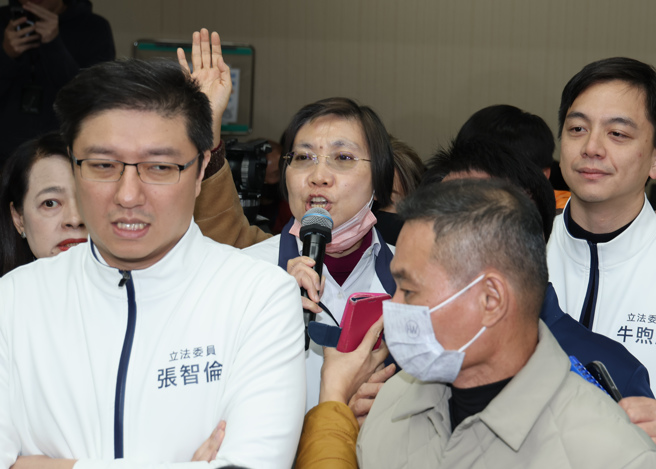 民进党立委18日占领内政委员会主席台，要求不得或暂缓确认16日会议议事录，召委徐欣莹（中）在国民党立委陪同下，于下午2点前进入会议室宣布开会及延长开会时间。（姚志平摄）