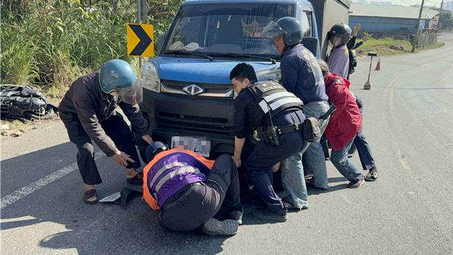 眾人合力把货车抬起来，让骑士脱困，由救护人员进行检伤。(吕妍庭摄)