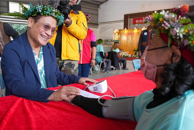 屏东县来义乡义林文健站揭牌启用，原民会主委曾智勇（左）担任一日照服员，为长者量血压。（原民会提供／罗琦文屏东传真