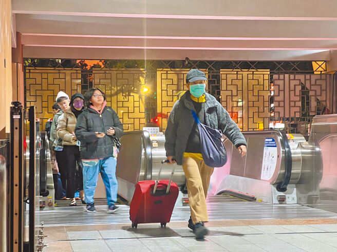 近日气温骤降，许多民眾外出时都会穿着厚重衣物、戴口罩、帽子御寒。（吕健豪摄）