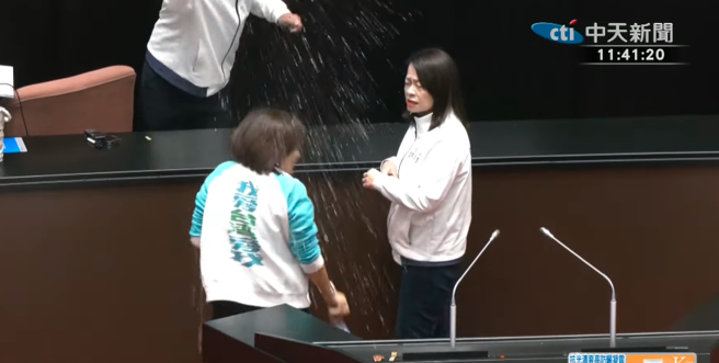 立法院長韓國瑜11點41分走上主席台，民進黨立委邱議瑩對著韓國瑜猛潑水，藍委見狀也拿出水瓶對著邱議瑩灑水。（取自中天新聞）