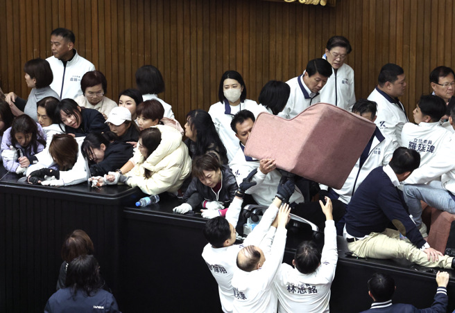 立法院會20日處理選罷法、憲法訴訟法及財劃法修正草案，民進黨多名立委進入議場後鎖門，綠營立委則佔領主席台及側門互相對峙，藍營破門進入議場，將綠委一位位請走。（鄧博仁攝）