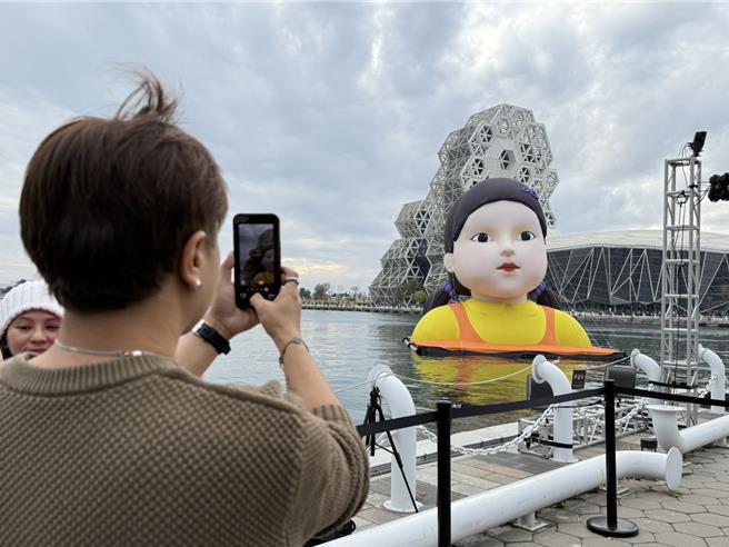 大型IP「英熙」娃娃降临高雄港，大批民眾今日下午涌入高流中心周边拍照打卡。（纪爰摄）