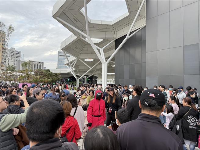 不少民眾抢着要与「粉红守卫」合照，不过有民眾抱怨「一直有人插队」。（纪爰摄）