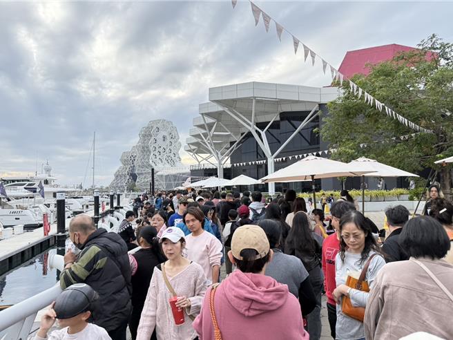 今日下午大批人潮湧入高流中心，與「英熙娃娃」合照，高雄捷運將視情況加發機動性加班車。（紀爰攝）