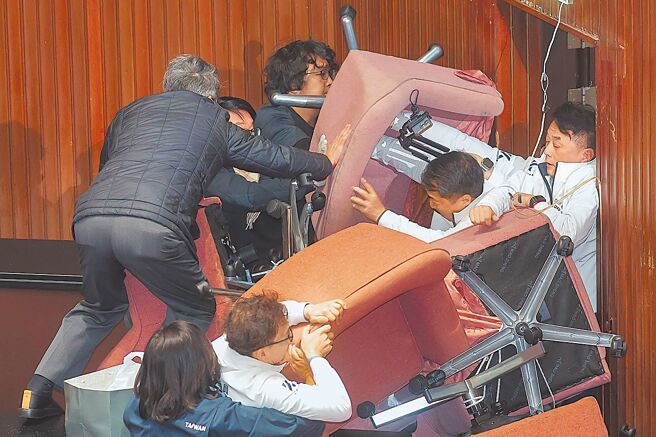 立法院會20日處理選罷法、憲法訴訟法及財劃法修正草案等案，民進黨立委和國民黨立委再爆發肢體衝突，藍營試圖衝破擋住門口的椅子。（資料照／郭吉銓攝）