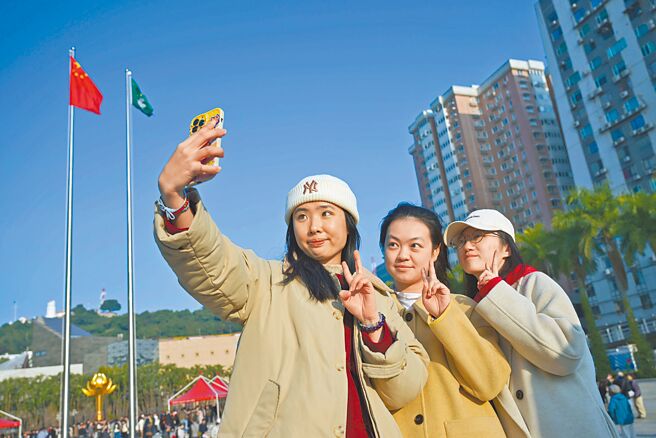 陸委會指出，澳府對我澳門辦事處新任人員設置「一中承諾書」障礙，目前僅餘2名派駐人員。圖為澳門市民20日參加回歸25周年升旗儀式。（新華社）