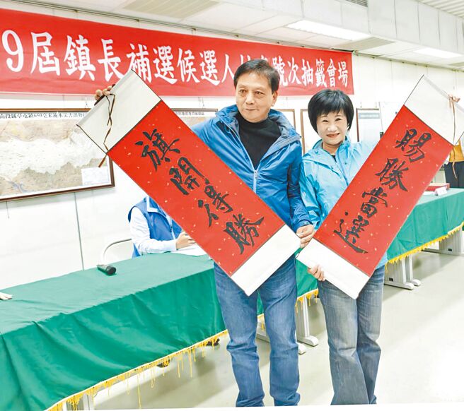 国民党草屯镇长补选候选人简赐胜（左）抽中2号，与妻子陈丽华高举「旗开得胜」、「赐胜当选」。（简赐胜提供／杨静茹南投传真）