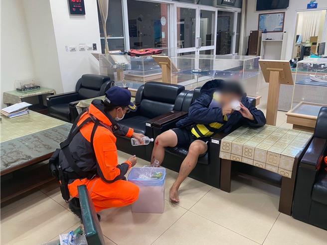 落海民眾被救回后，因脚部多处被蚵棚刮伤，海巡人员协助包扎伤口。（读者提供／洪荣志台南传真）