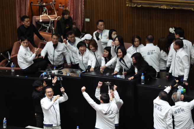 立法院会20日处理选罢法、宪法诉讼法及财划法修正草案，民进党多名立委进入议场后锁门，绿营立委则占领主席台及侧门互相对峙，直到上午10点40分国民党将所有绿委请出议场后，蓝委举手欢呼。（中时资料照，邓博仁摄）