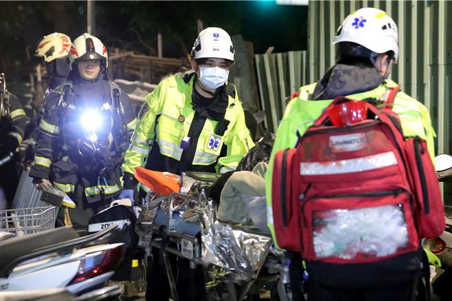 新北市板桥区23日凌晨0时许发生火警，救护人员用担架将救出的住户送医。（黄世麒摄）